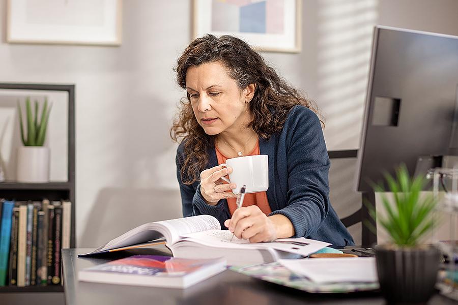 Woman studies at table in home